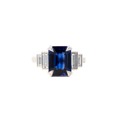 Diamond ring with a blue gemstone on a white background