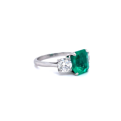 3.42ct Emerald Cut Emerald and Round Diamond Three Stone Ring